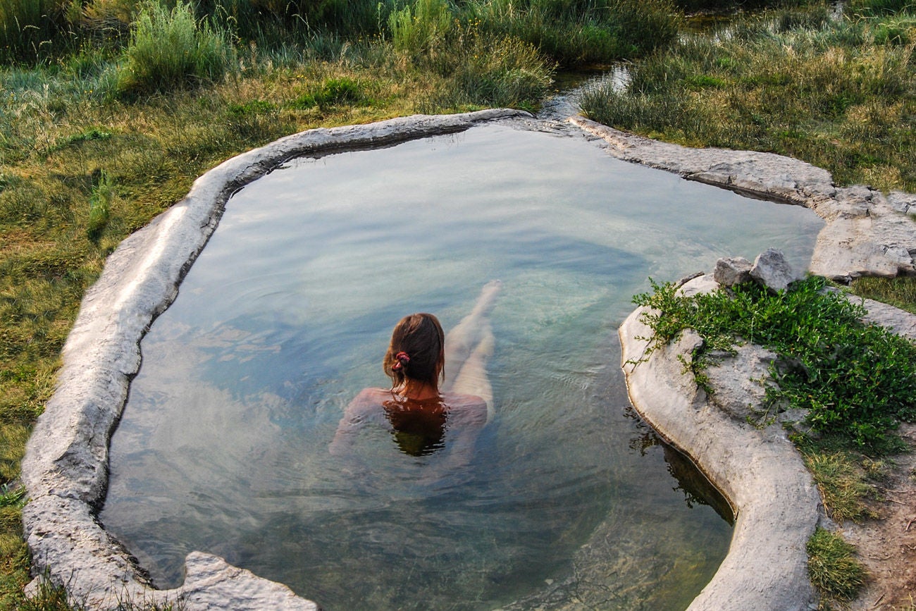Woman soaking in a hot spring pool in the Eastern Sierra Nevada near Mammoth Lakes, California.