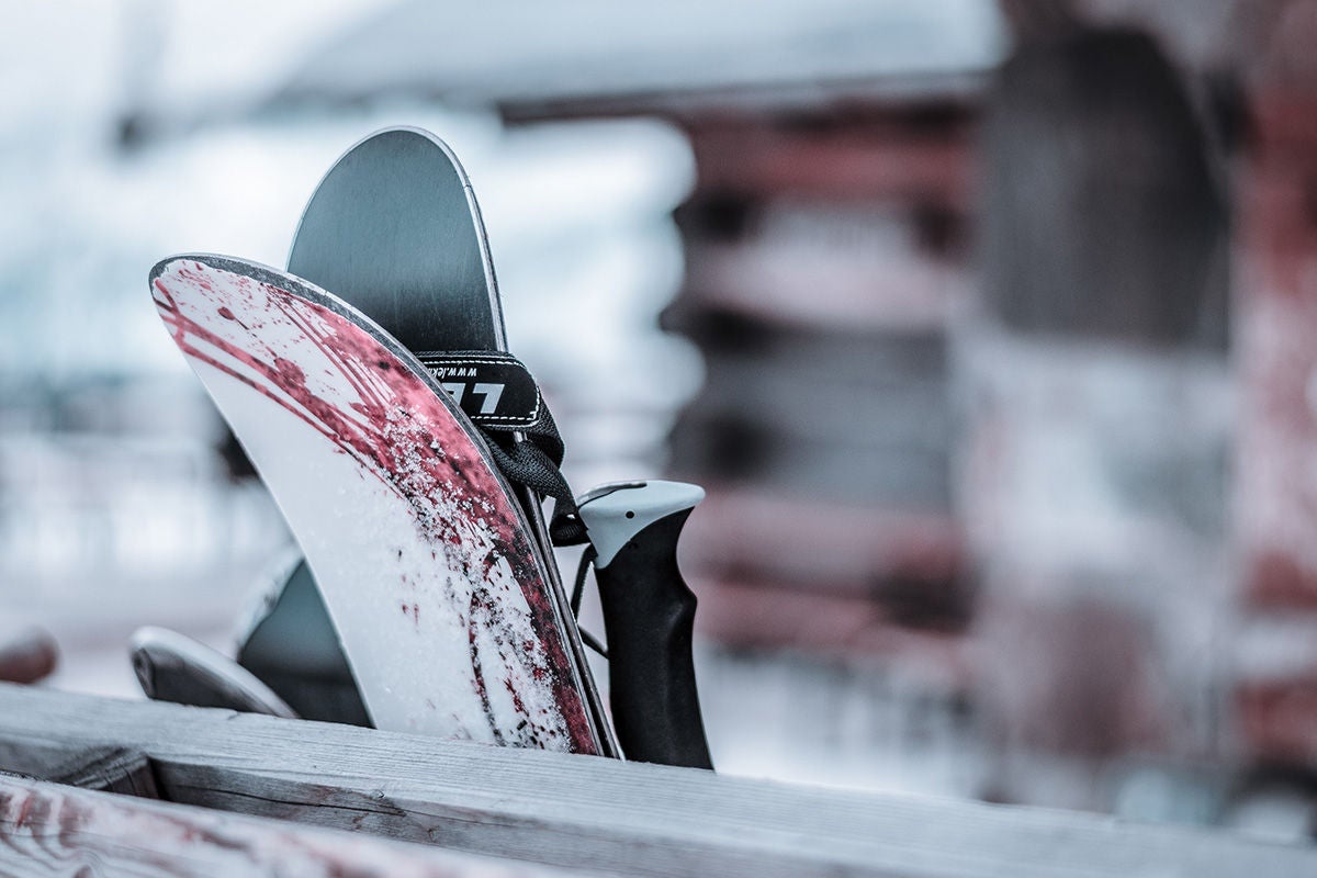 Skis leaning against a wooden post.