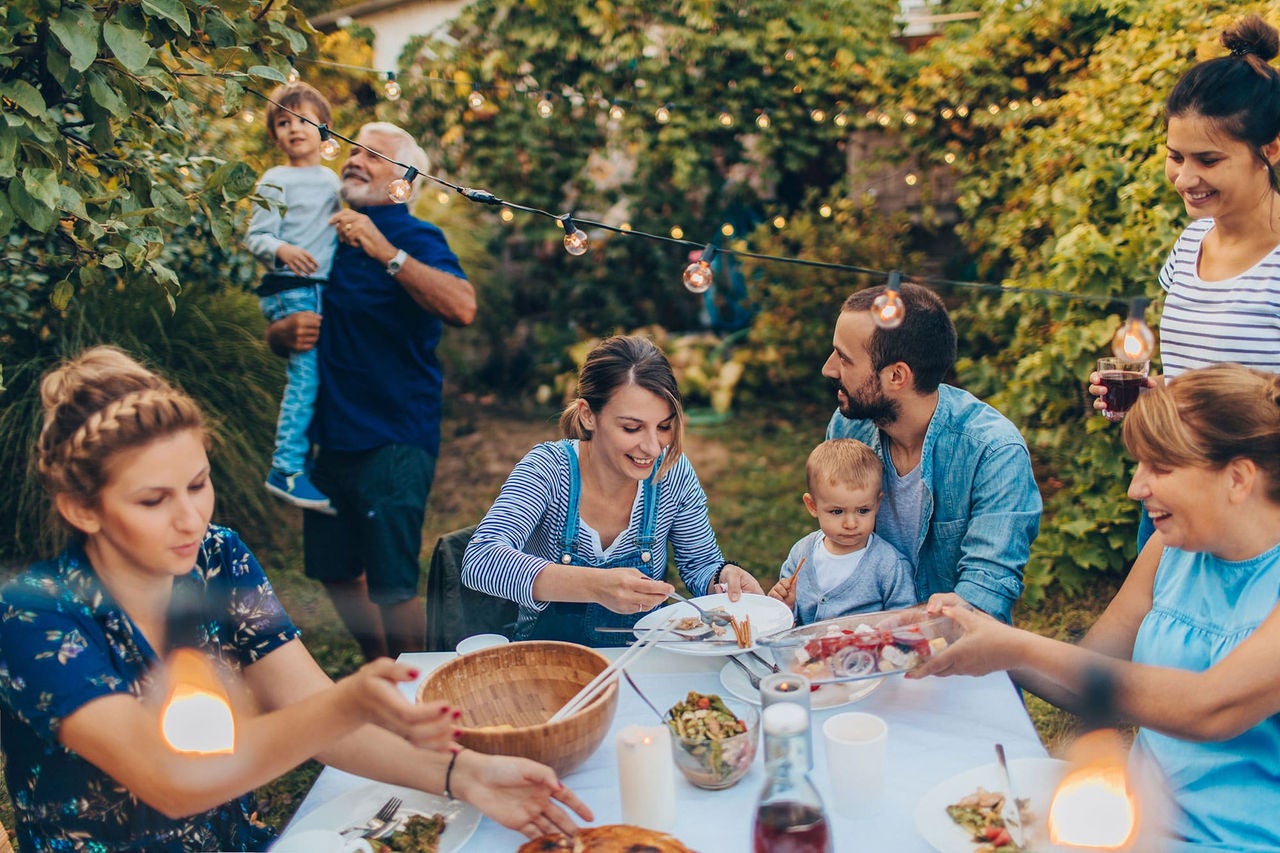generational family eating dinner and celebrating outdoors