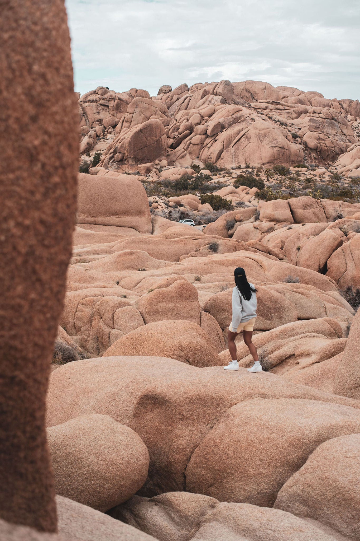Woman walking on rock formations in Joshua Tree, California