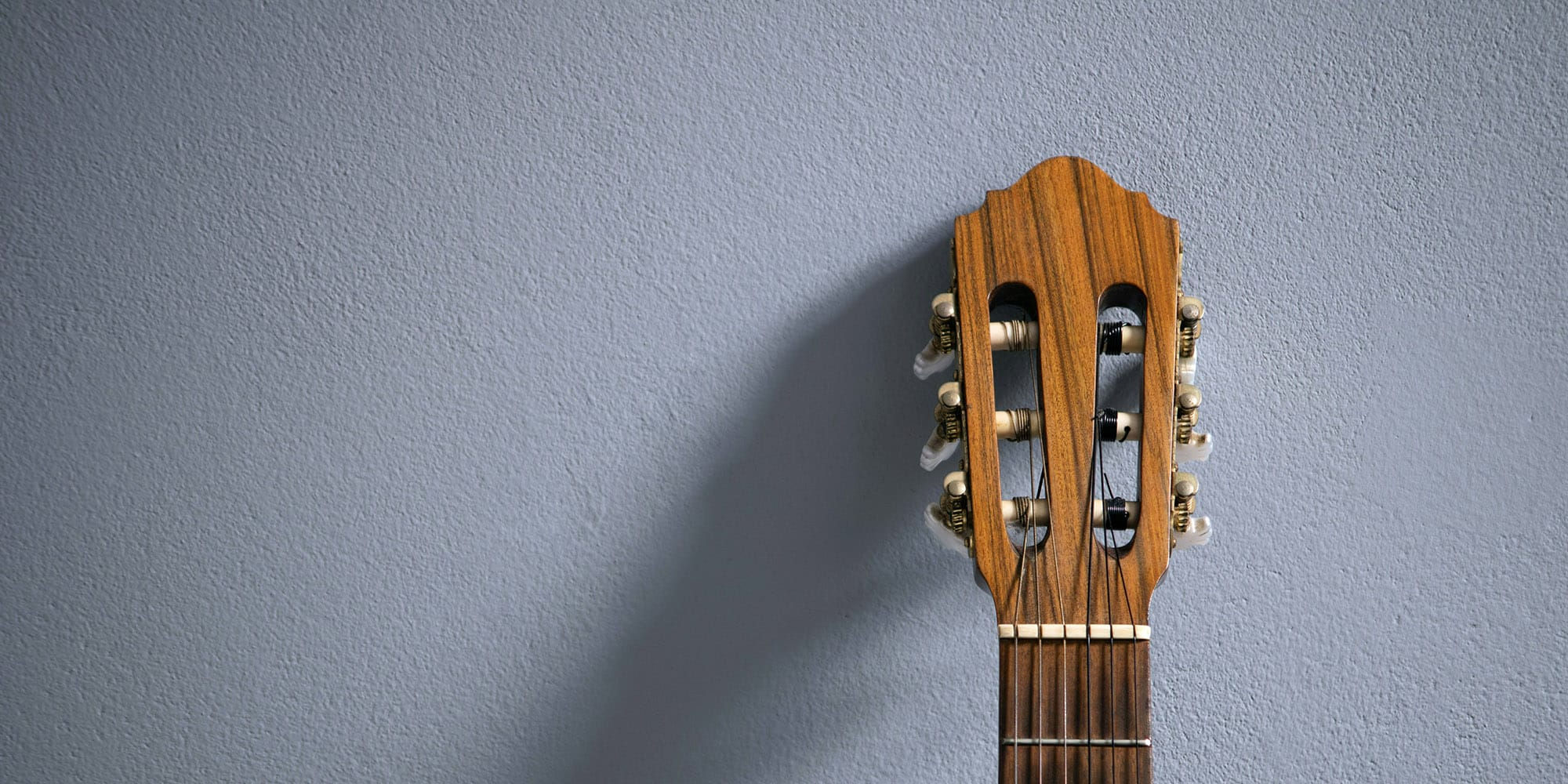 guitar leaning against a blue wall